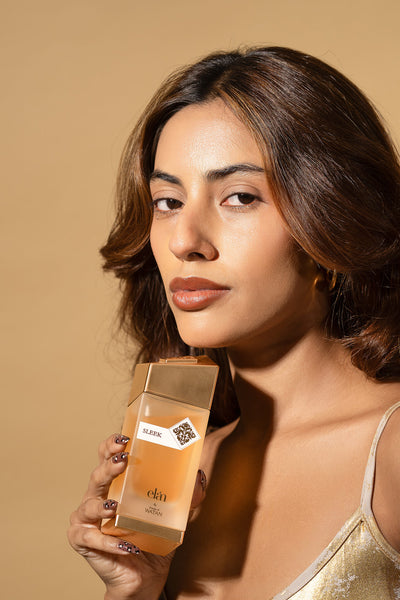 Woman in gold holding Sleek Eau de Parfum, House of Watan