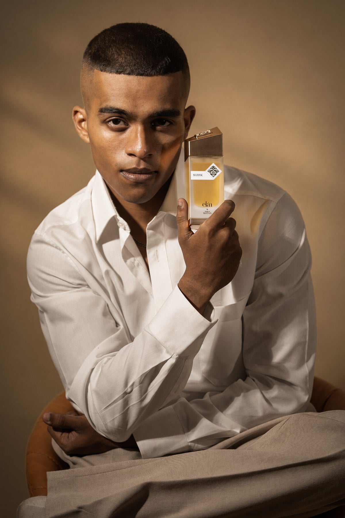 Man holding Sleek by House of Watan, boozy gourmand fragrance
